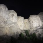 Mount Rushmore sculpture with a black night sky background
