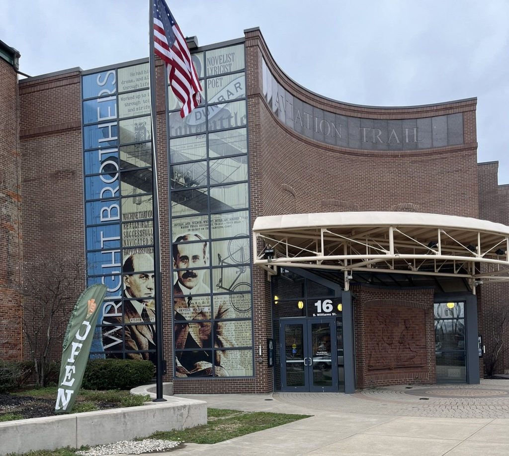 Wright-Dunbar Interpretive Center exterior with Wright Brothers exhibits signage and Aviation Trail building