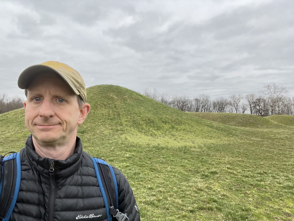 Ohio National Parks: Your Complete Visitor Guide (2026) 2 Hopewell Culture National Historical Park in Chillicothe Ohio — ancient earthwork mounds with man with ball cap standing in front of them