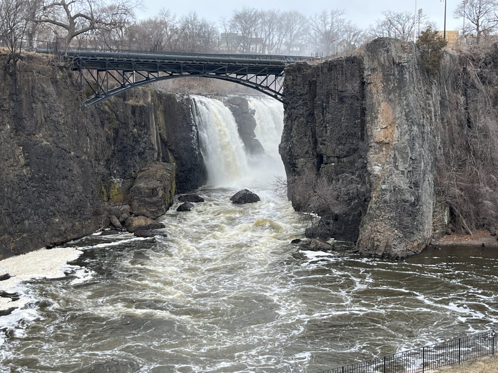 The Great Falls of the Passaic River at Paterson Great Falls National Historical Park in New Jersey, with the historic iron arch bridge framing the 77-foot waterfall.