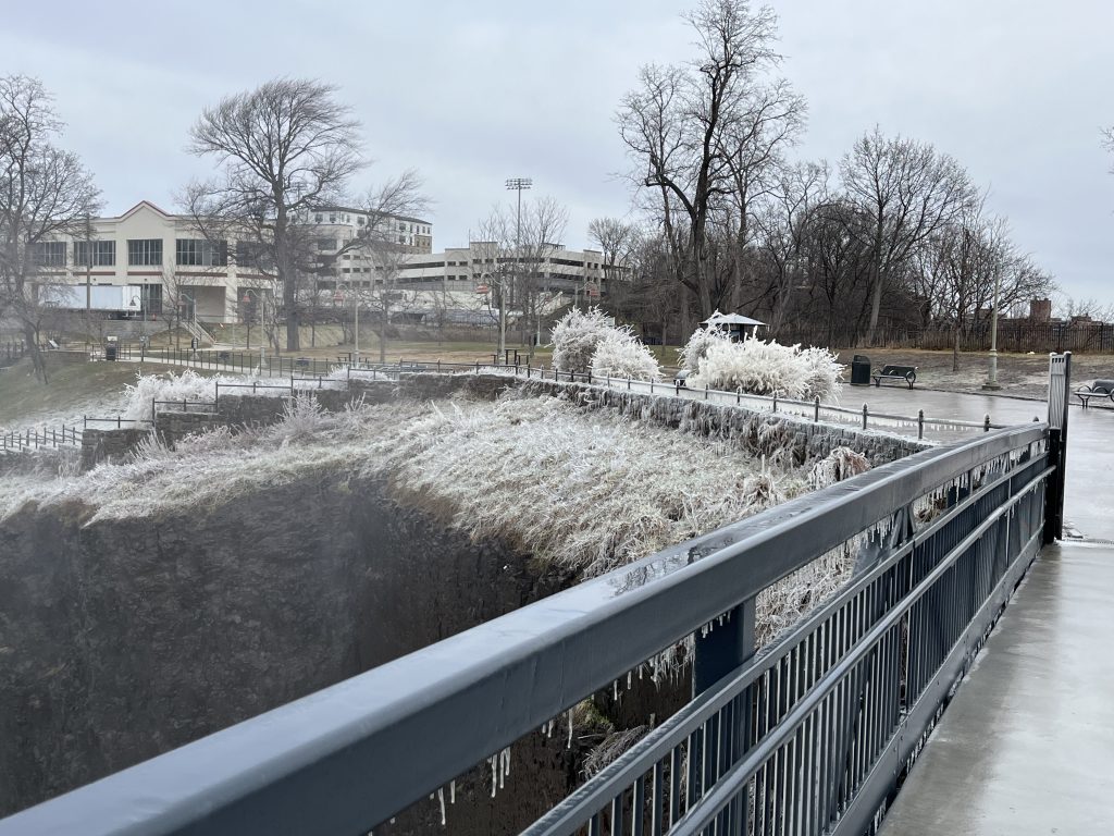 Frost-covered overlook walkway at Paterson Great Falls National Historical Park in winter with ice-coated vegetation along the gorge edge