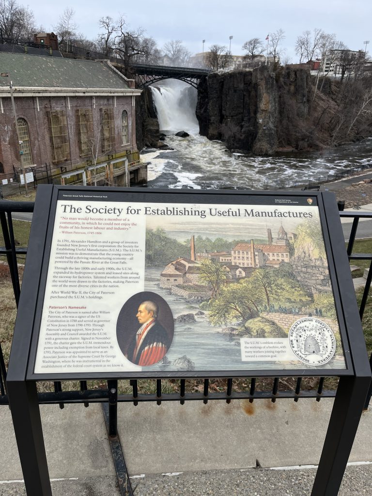 Interpretive sign at Paterson Great Falls NHP explaining the Society for Establishing Useful Manufactures and Alexander Hamilton's industrial vision.