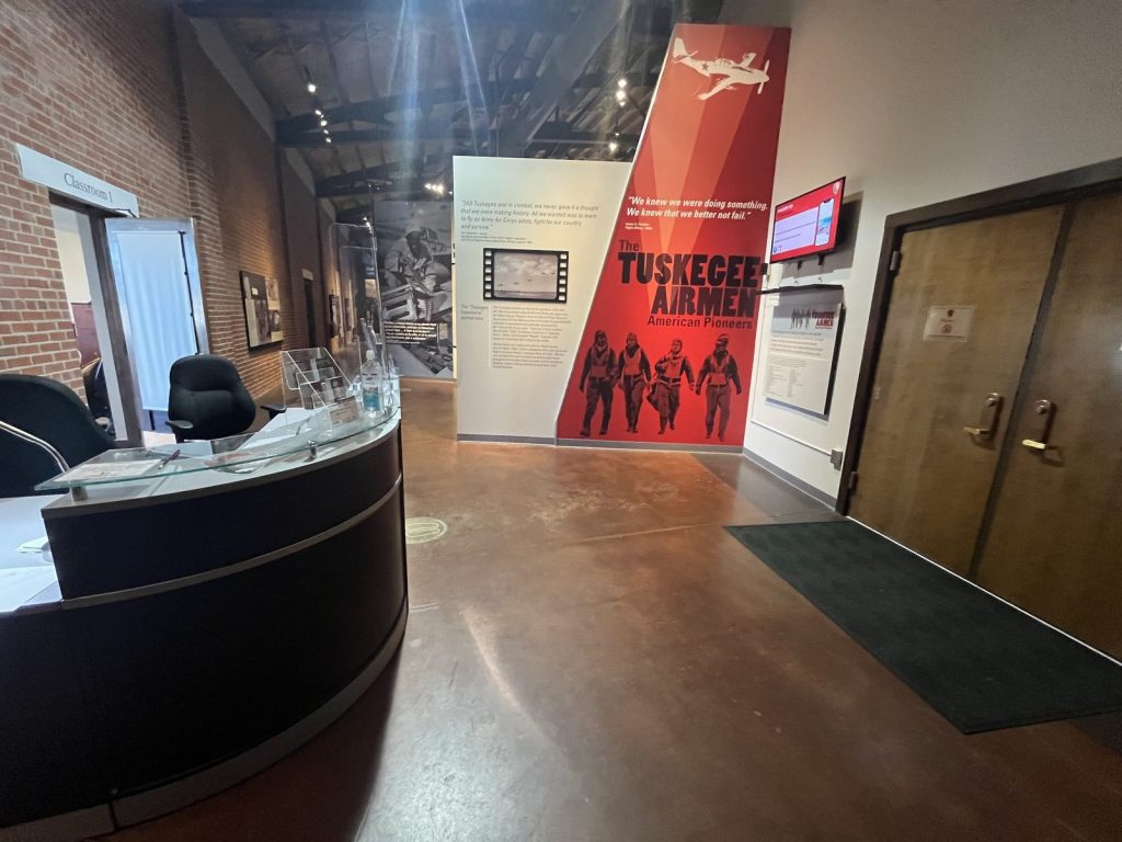 Lobby of Hangar 1 at Tuskegee Airmen NHS showing the front desk and Tuskegee Airmen American Pioneers exhibit banner