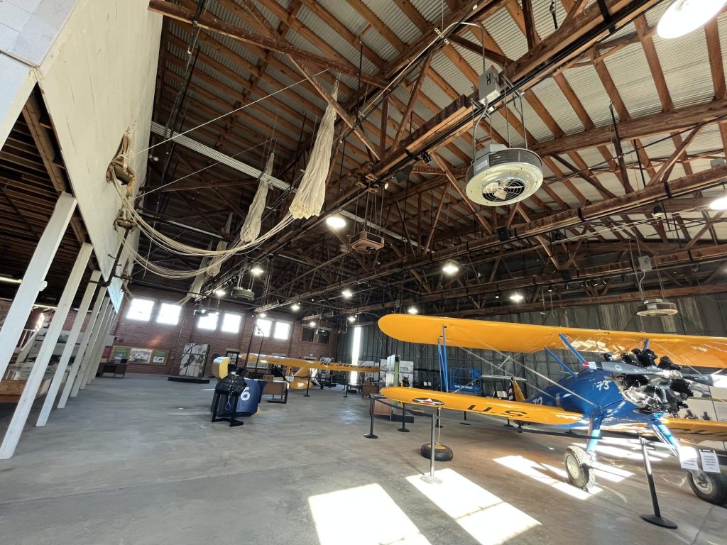 wide view of Hangar 2 interior at Tuskegee Airmen NHS showing training aircraft and exhibits on the original Moton Field