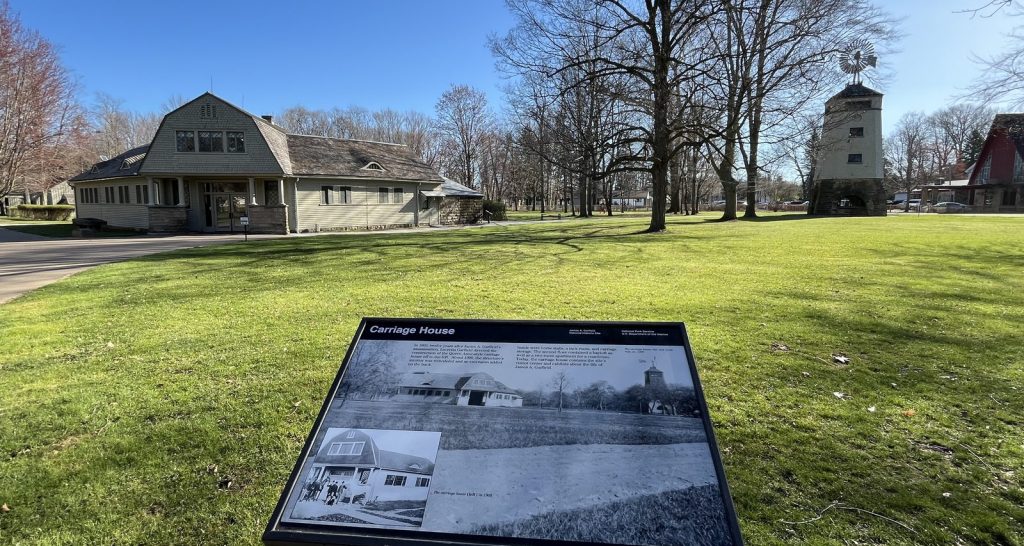 nterpretive panel for the Carriage House with the windmill tower visible in the background at Garfield NHS