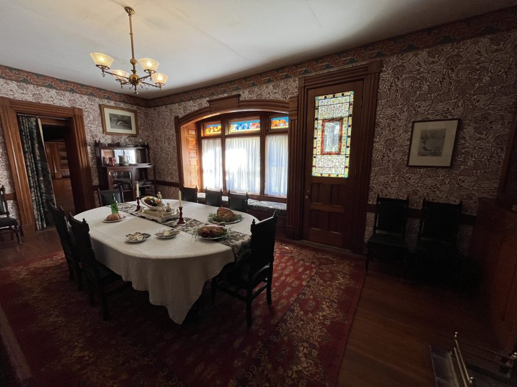 Dining room with stained glass windows and set table inside Lawnfield at Garfield NHS