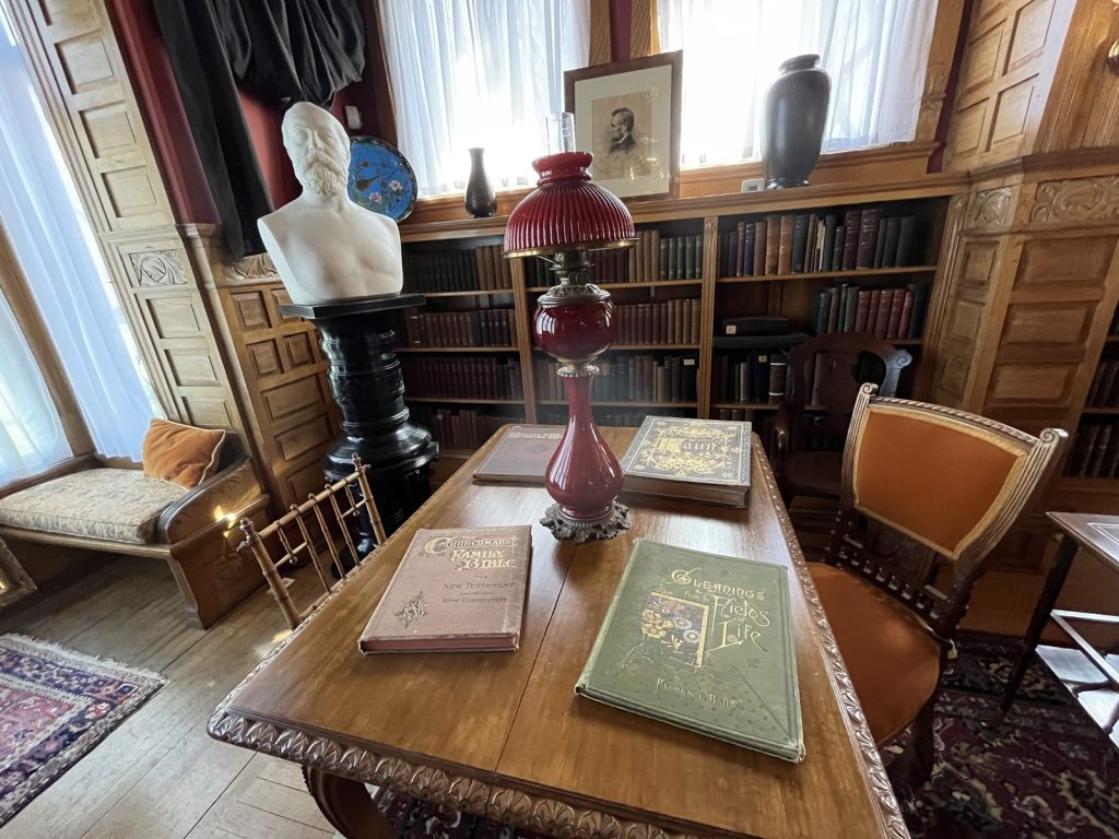 Library table with books and bust inside Lawnfield at James A. Garfield National Historic Site