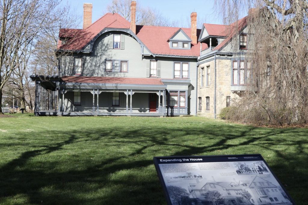 Side lawn view of Lawnfield with the Expanding the House interpretive panel at Garfield NHS