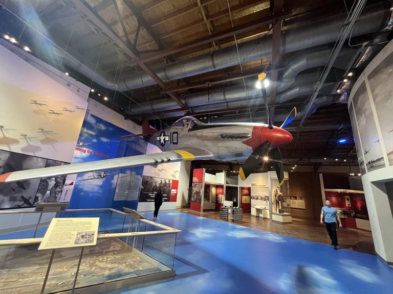 See P-51 red-tail Mustang replica suspended in the main exhibit hangar while visiting Tuskegee Airmen National historic Site