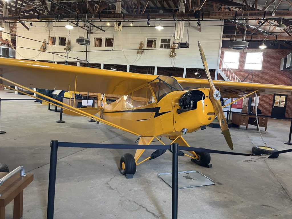 Yellow Piper J-3 Cub primary trainer aircraft on display in Hangar 2 at Tuskegee Airmen National Historic Site