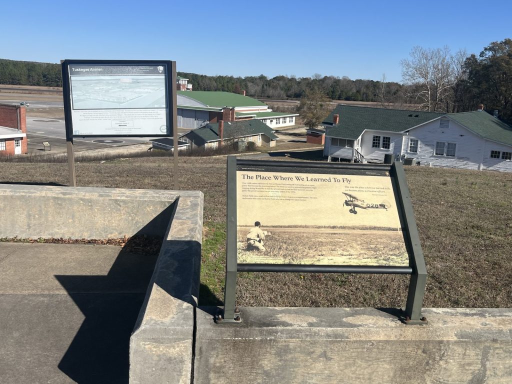 The Place Where We Learned to Fly interpretive panel at Moton Field Tuskegee Airmen NHS with hangars in background