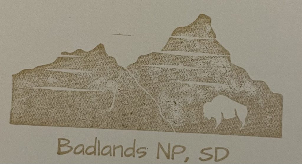 Badlands National Park passport stamp showing the layered buttes and a bison