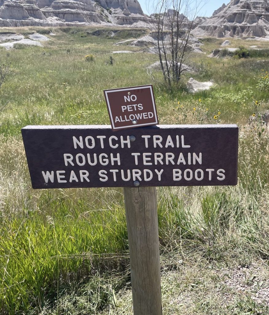 Notch Trail trailhead sign reading Rough Terrain Wear Sturdy Boots with No Pets Allowed sign above