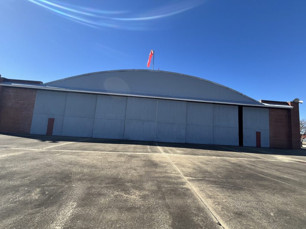 Hangar 2 exterior close-up with American flag flying from the roofline at Tuskegee NHS