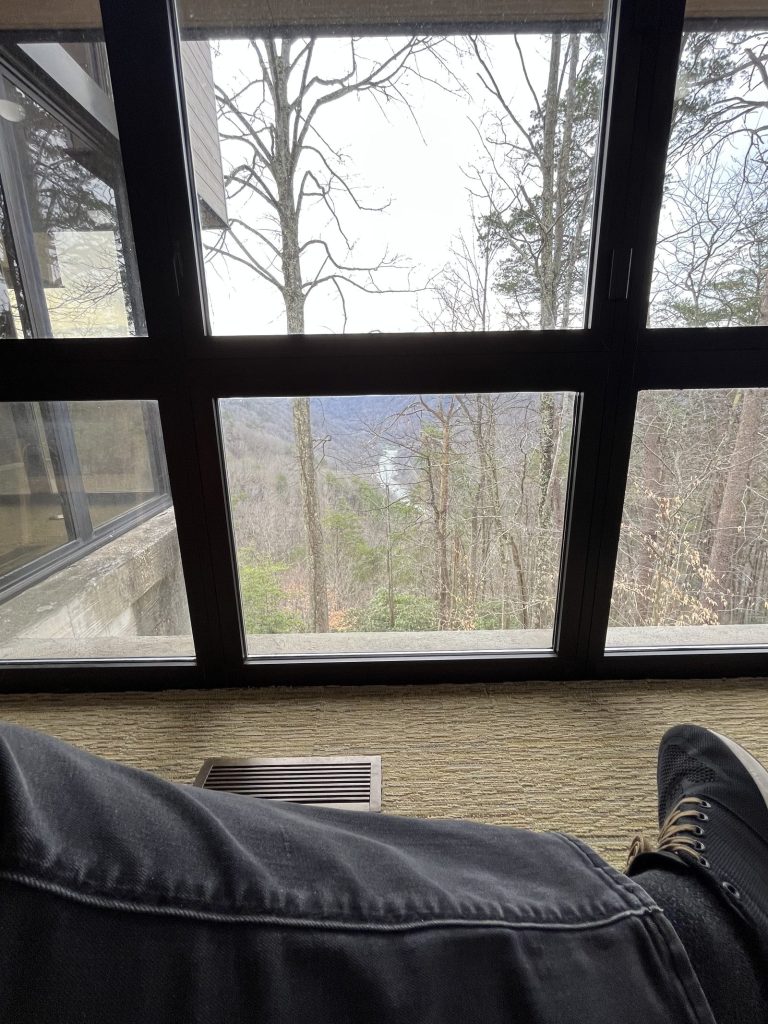 Wooden rocking chairs at Canyon Rim Visitor Center New River Gorge facing large windows overlooking gorge