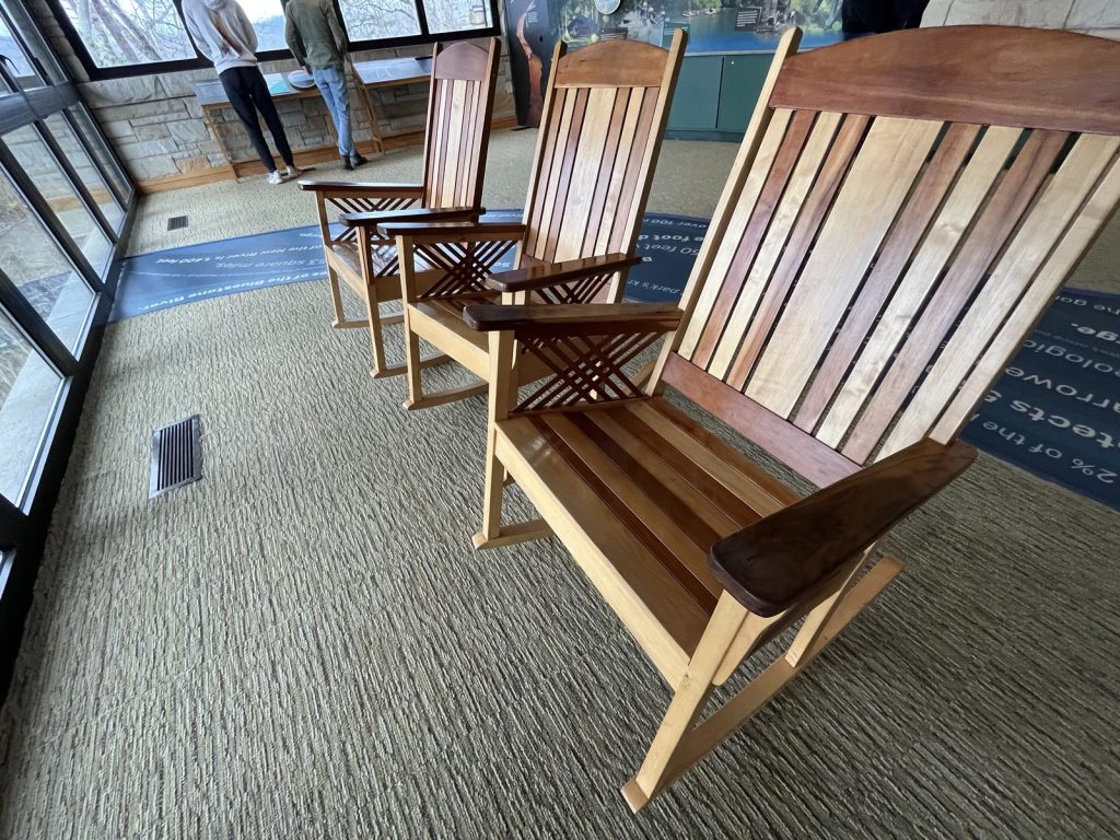 iew from rocking chair at Canyon Rim Visitor Center looking through large windows toward New River Gorge and bare winter trees