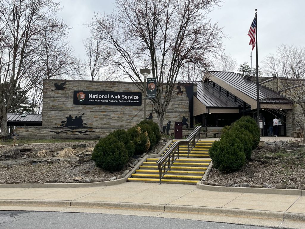 xterior of Canyon Rim Visitor Center at New River Gorge National Park with NPS arrowhead sign and flag