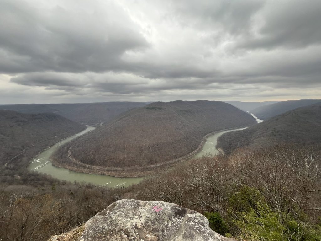 anoramic view of New River Gorge canyon with river winding through forested hills from Grandview overlook 