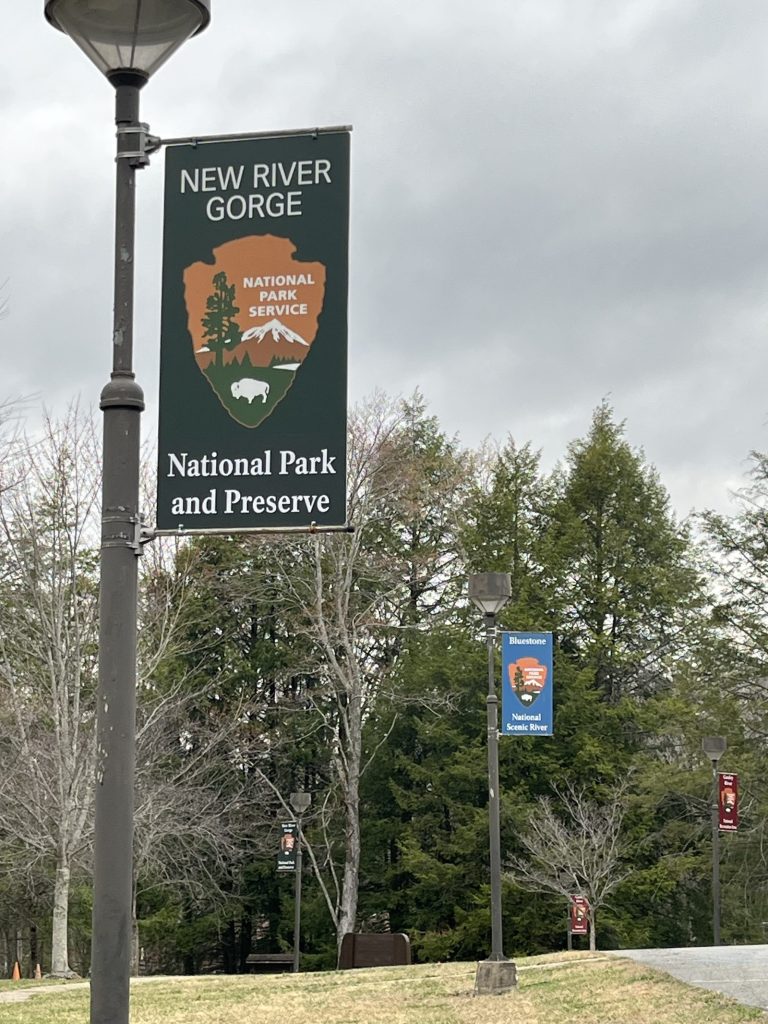 New River Gorge National Park and Preserve NPS banner on lamp post with green trees in background