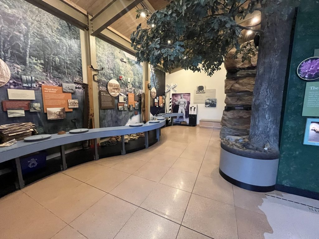 John Henry Steel Driving Man exhibit at New River Gorge visitor center with life-size illustration and audio listening stations and other exhibits