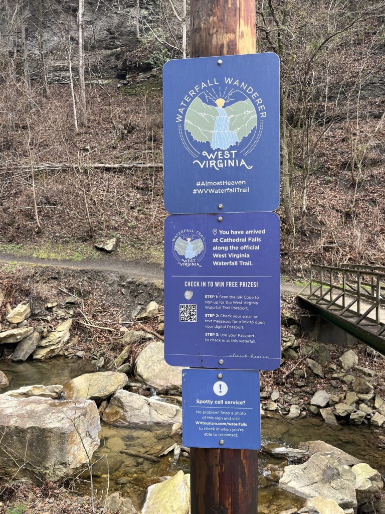 Waterfall Wanderers West Virginia trail sign with QR code near waterfall at New River Gorge National Park