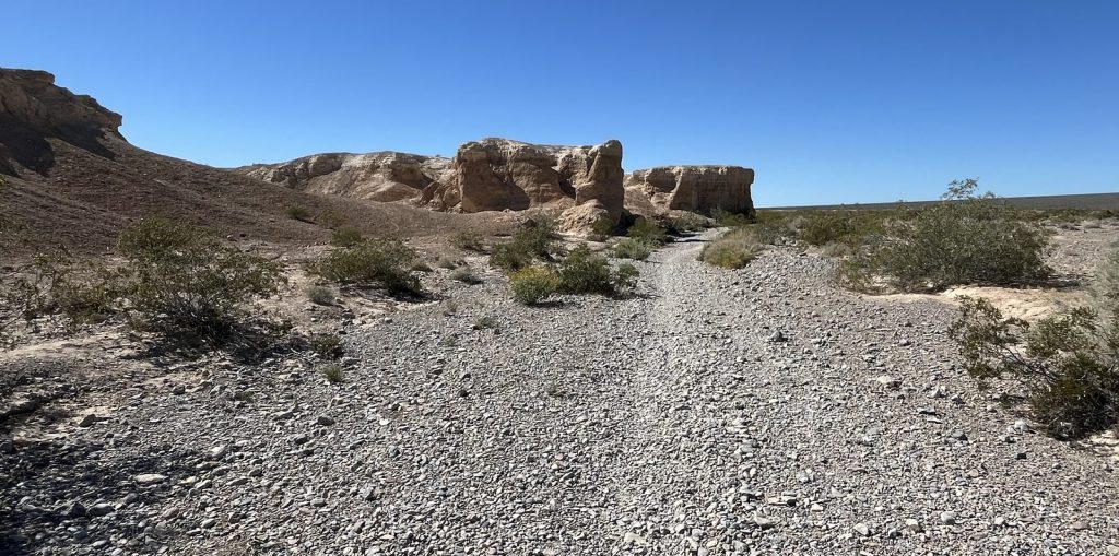 Gravel trail through dramatic red and tan rock formations on the Durango Loop at Tule Springs Fossil Beds National Monument
